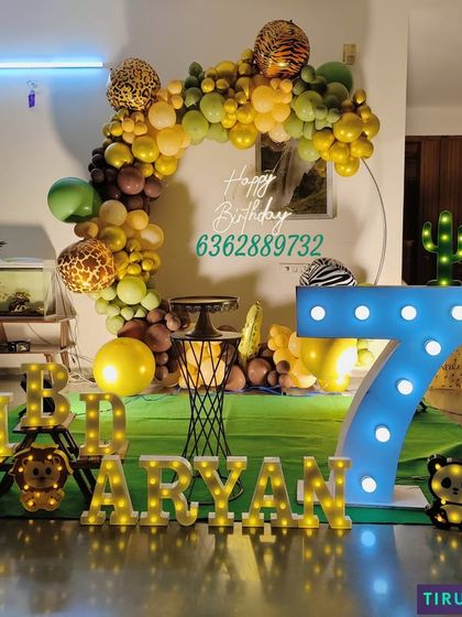 Another view of Aryan's jungle themed surprise party, showing the full setup with the large illuminated number '7' and green floor mat.