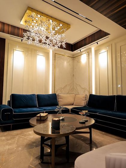 Another angle of the living room with the royal blue velvet sofa, showing how the warm lighting and classic wall paneling create a cozy and elegant atmosphere.