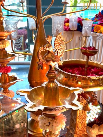 A detailed shot of a traditional brass peacock lamp (Annapakshi Vilakku), a beautiful and auspicious element in South Indian decor.