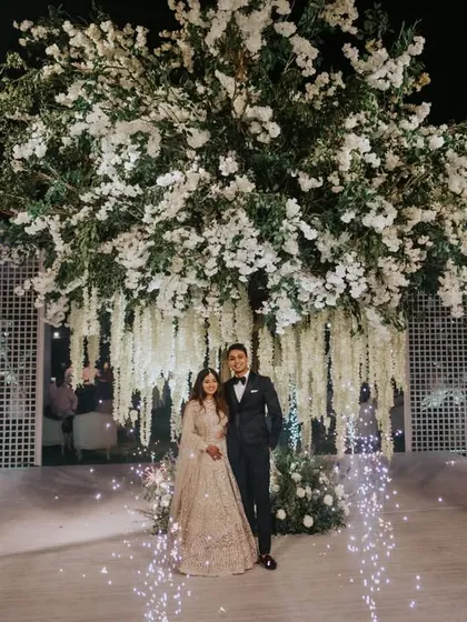 The same 'Tree of Life' installation transforms at night. With the addition of sparklers and dramatic lighting, it becomes a magical focal point for a couple's reception entry.