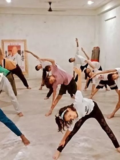 Students performing Trikonasana (Triangle Pose). This yoga asana is excellent for stretching the sides of the body and improving stability.