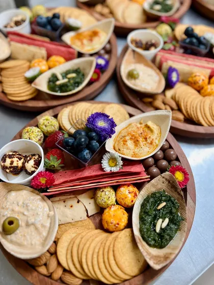 Another angle of the cheese and dips platters, showing the variety of crackers, fruits, and dips. We use edible flowers to add a pop of colour and a touch of elegance.