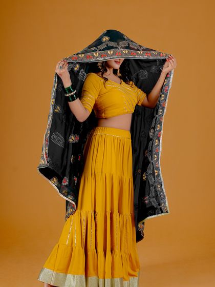 A vibrant studio shot with a bold yellow background that complements the model's traditional ghagra choli. I use color to create striking and memorable fashion images.