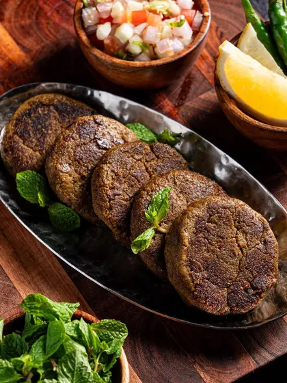 An overhead shot of the kebabs, garnished with fresh mint and served with lemon. This top-down angle is highly effective for menu photography and social media posts.