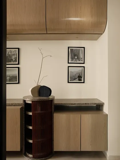 A custom-designed console in the passage, featuring a unique cylindrical storage unit in a deep red. This piece showcases our commitment to creating bespoke furniture that is both beautiful and functional.