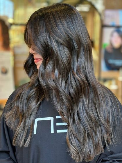 The back view of a perfectly executed balayage. The highlights are painted to mimic where the sun would naturally lighten the hair, creating a seamless, lived-in look.