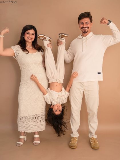 This family is all about fun. The parents flex their muscles while holding their daughter upside down, creating a hilarious and memorable family portrait that perfectly shows their playful dynamic.