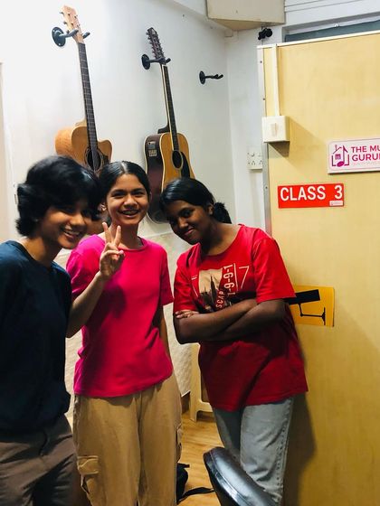 A candid moment of friendship and fun outside the classroom door. The bonds formed at The Music Gurukul are a special part of the experience.