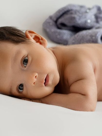 Sometimes, the most beautiful portraits are the simplest. This image captures a baby's curious, alert expression with a minimalist approach, using soft, natural light to highlight their beautiful eyes and smooth skin.