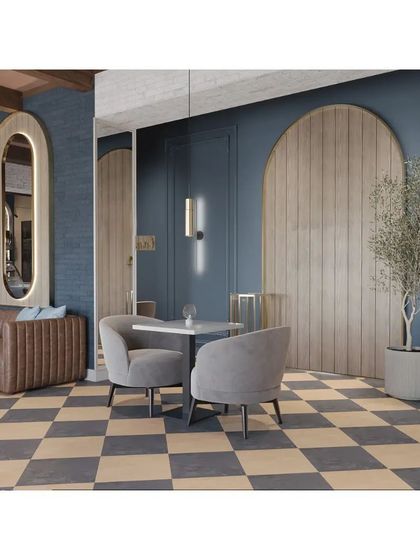 A seating nook with a comfortable brown leather banquette against a deep blue wall. The large, gold-framed mirror and wood-paneled feature add warmth and sophistication.