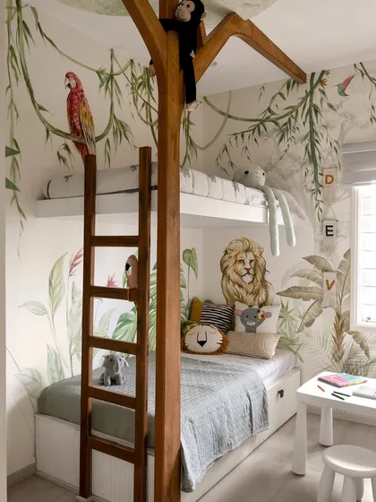 Designing for children is about creating a world for their imagination. This jungle-themed room uses a custom treehouse bunk bed and wall-to-wall murals to turn a compact space into a playful safari escape.