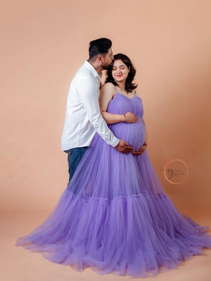 A tender forehead kiss, a classic pose that beautifully captures the love and protection in a relationship. The soft lavender gown complements the gentle mood of this couple's portrait.