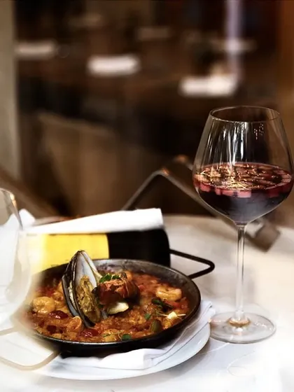 A classic Spanish pairing: our rich seafood paella served alongside a refreshing glass of red wine sangria.