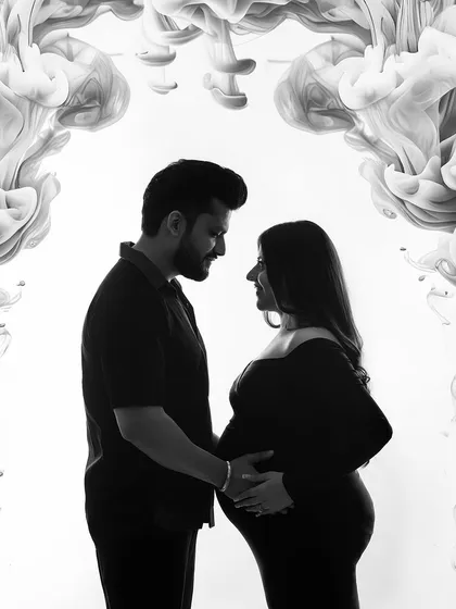 A creative black and white silhouette of a couple, framed by an abstract smoke effect. This artistic approach creates a modern and visually striking maternity portrait.