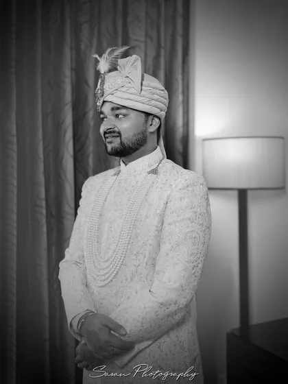 A timeless black and white portrait of the groom in his wedding attire, looking poised and ready.