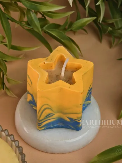 A playful star-shaped Jesmonite candle holder with a blue and yellow marbled effect.
