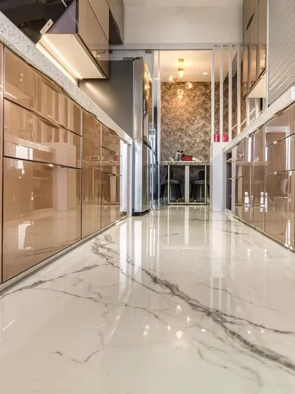 A low-angle shot of the back-painted glass cabinets, reflecting the marble flooring and creating a sense of luxury.
