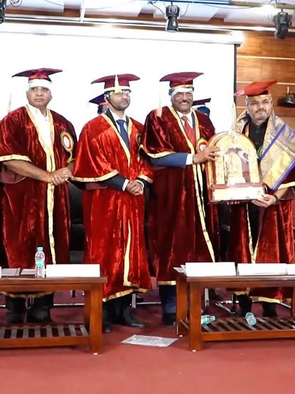 A group photo with the college leadership, holding the memento I was presented with.