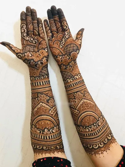 A full-arm bridal design with dense, intricate patterns. This style ensures a very dark and rich henna stain.
