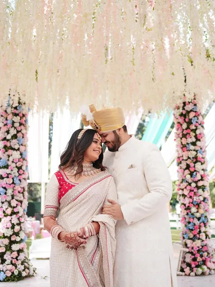 Framed by a stunning floral canopy, the couple shares a moment of quiet intimacy. This is the kind of romantic, grand-yet-personal shot we specialize in.