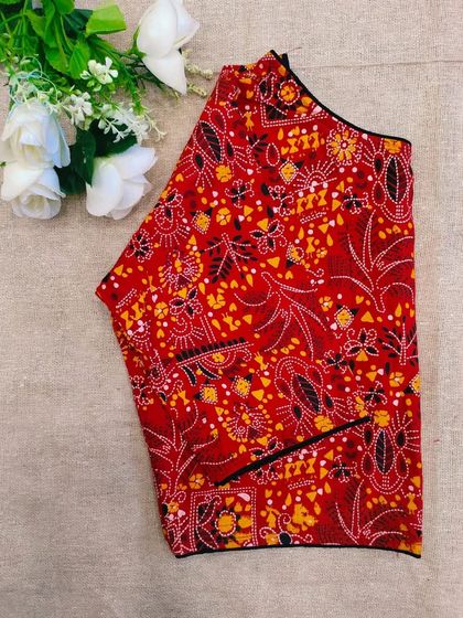 A bright red cotton boatneck blouse with an intricate all-over print.