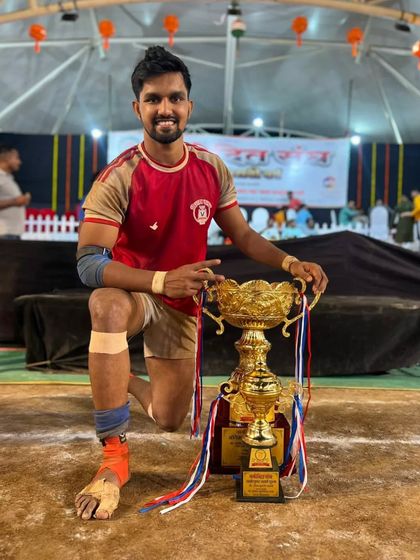 Raj Natekar posing with his 'Best Raider' trophy on the mat.