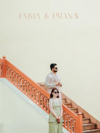 A modern, minimalist portrait of the couple on a striking orange staircase. This image has a high-fashion feel, showcasing their cool, contemporary style during their pre-wedding festivities.