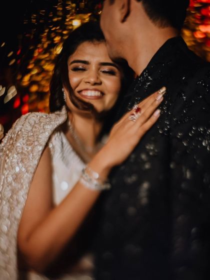 A candid, happy moment of the couple at their Sangeet, her smile lighting up the frame.