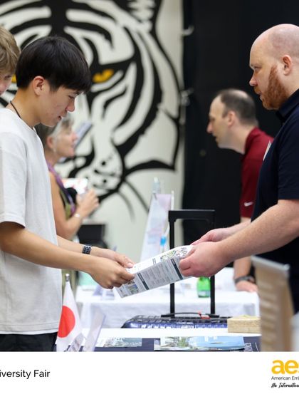 A student from our diverse international community receives information from a university representative. We provide high school application support for universities in any country, catering to our global student body.