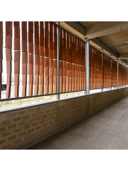 The view from the balcony behind the terracotta jaali screen at the RSL Office. This semi-open space acts as a buffer, protecting the interiors from direct sun and rain while allowing for natural ventilation.
