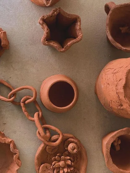 A collection of small, imaginative pieces made from terracotta clay. Each one is a little world of its own.