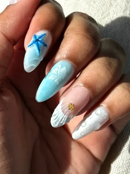 A close-up of the ocean-themed nails, focusing on the 3D starfish and hibiscus flower details.