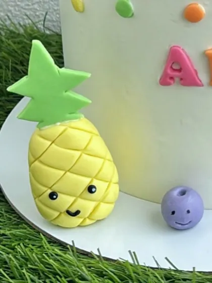 A detailed shot of the cute pineapple and blueberry fondant figures.