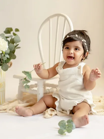 Another adorable shot from this sitter session. Her happy expression and the classic white setup are a perfect combination.