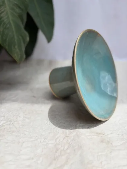 An artistic shot of the elevated plate, highlighting its sleek lines and the beautiful turquoise glaze.