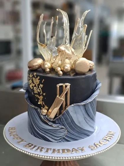For the Master Blaster, Sachin Tendulkar, I designed this special cricket themed birthday cake. It features a black and grey marbled tier, edible gold leaf, and a sculpted sugar cricket bat and wickets, making it a truly personal and celebratory piece.