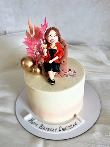 A cake from an adoring husband to his wife, featuring a hand-sculpted figurine of her relaxing with a glass of wine.