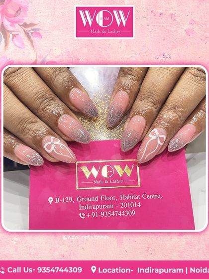 A delicate and feminine design on long, stiletto extensions. This look features a soft pink glitter ombré with beautifully hand-painted white bows, perfect for a romantic vibe.