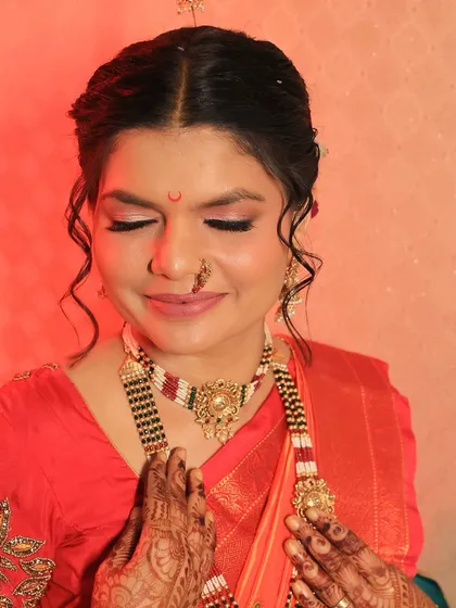 A serene moment captured. The soft eye makeup and traditional jewelry create a look of pure grace for this Maharashtrian bride on her wedding day.