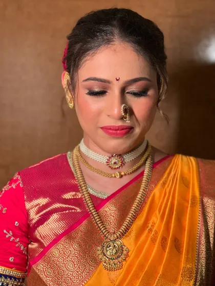 A soft, elegant portrait showing the details of the eye makeup and traditional nath.
