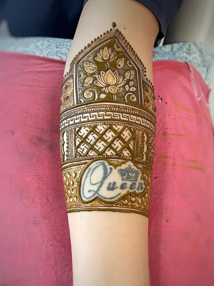 An armband design that incorporates a client's existing 'Queen' tattoo. I can creatively build a mehndi design around your existing tattoos to create a unique, integrated look.