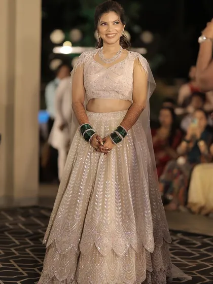 A full view of this bride's sangeet look. The light pink lehenga is paired with a soft glam makeup look, perfect for an evening of celebration.