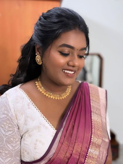 Subha smiling, happy with her final look. The makeup is natural and enhances her beautiful features.