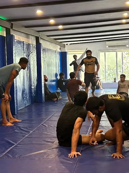 A student leans against the wall to catch his breath between rounds. Training is tough, but the feeling of pushing your limits and improving is what keeps us coming back.
