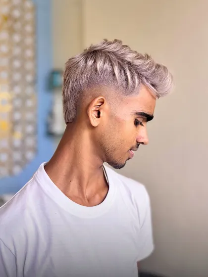 Precision is key. This custom ash color is paired with a seamless fade, creating a clean, modern, and edgy style. The texture on top allows for versatile styling.