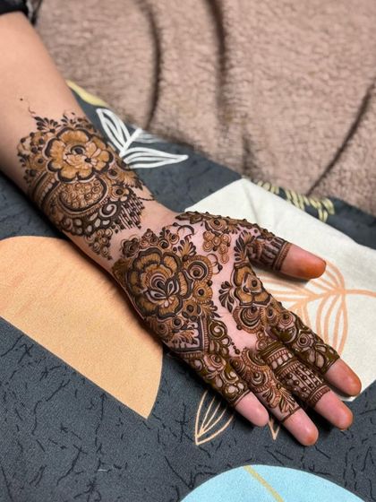 A floral design with a mix of bold and fine lines, covering the hand and wrist.