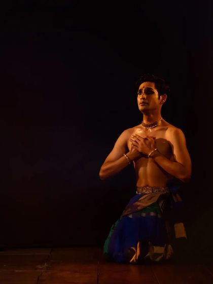 A moment of prayerful offering, or 'Anjali', during a performance. This gesture of respect to the divine, the stage, and the audience is an integral part of every recital.