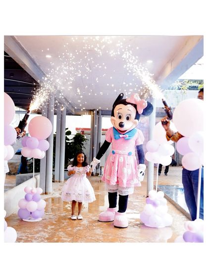 A magical entrance for the birthday girl with a Minnie Mouse mascot and celebratory sparklers, creating a truly memorable moment.