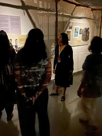 Visitors observing the archival boards in 'WEAVING LIGHT', which provided context on the history of textile production.