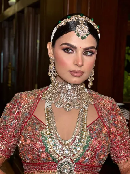 Radiating elegance and timeless beauty. This bride is a vision in red, with makeup that embodies the essence of a modern-day queen.